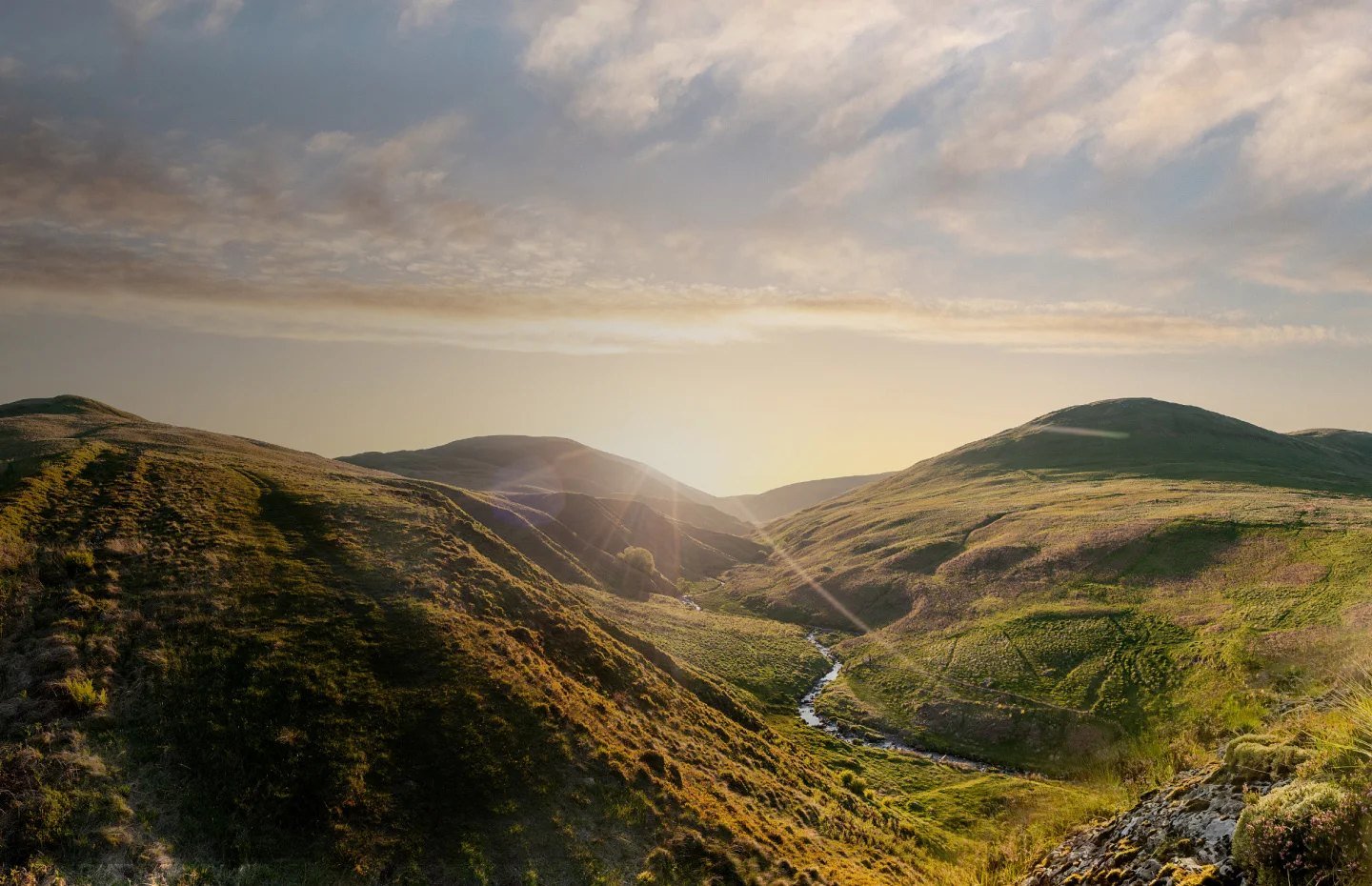 Sunrise over the Ochil Hills in Scotland, with a spring-fed burn running through the glen