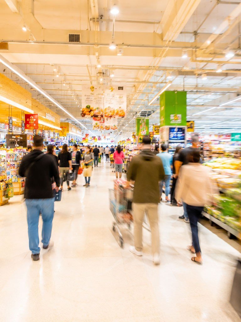 Shoppers moving through the main aisle of a busy super shop